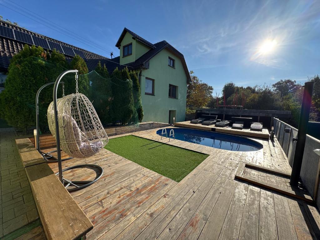 a backyard with a swing and a pool on a wooden deck at Chata Cerovo in Cerovo