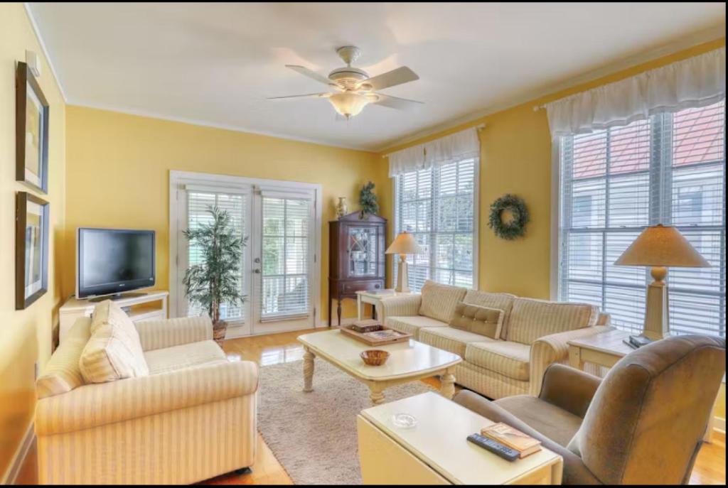 a living room with a couch and a tv at Bay Breeze - 3 Min Walk to Beach in Tybee Island
