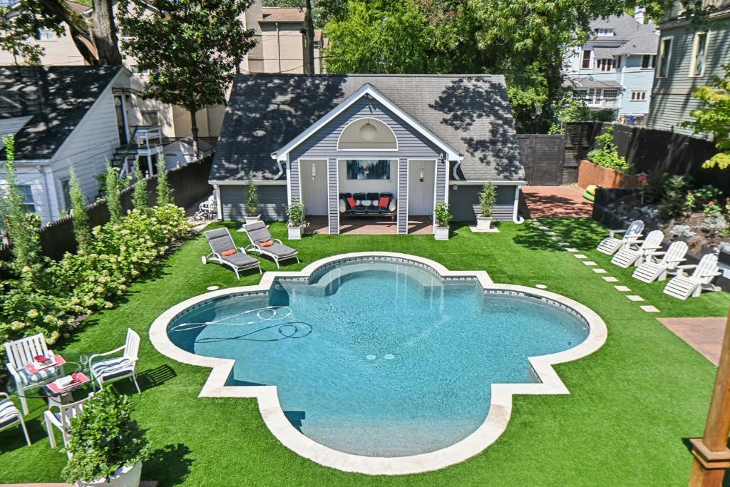 a backyard with a pool with chairs and a house at Midtown 6bed 5bath w pool and sauna in Atlanta