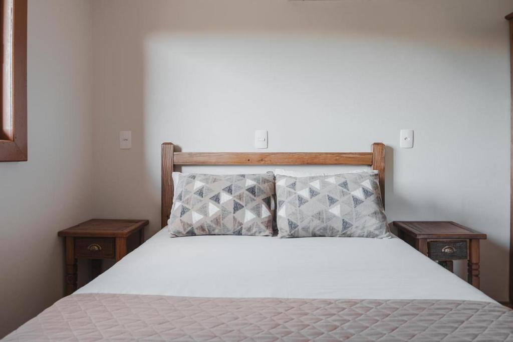 a bedroom with a bed with two nightstandiatesiatesiatesiatesiatesiatesiates at Casa, sítio, aconchegante no Vale dos Vinhedos. in Bento Gonçalves