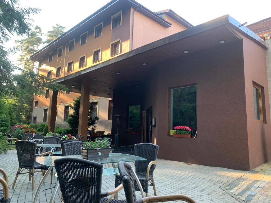 a patio with tables and chairs in front of a building at Laguna Resort SPA in Augustów