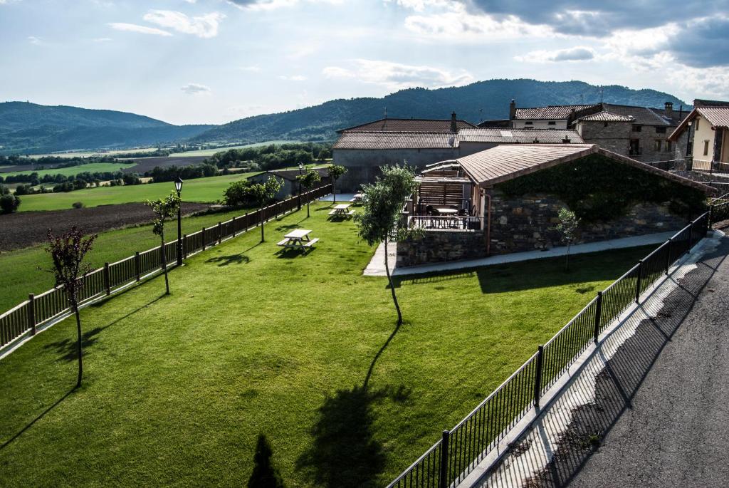 a fence with a green field and a building at Casa Lueza in Alueza