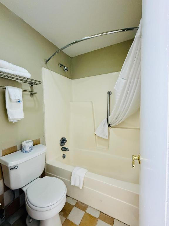 a bathroom with a toilet and a bath tub at Travelodge by Wyndham-Thomasville AL in Thomasville