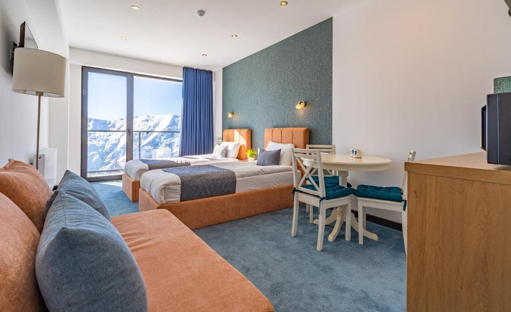 a hotel room with two beds and a table at New Gudauri Twins in Gudauri