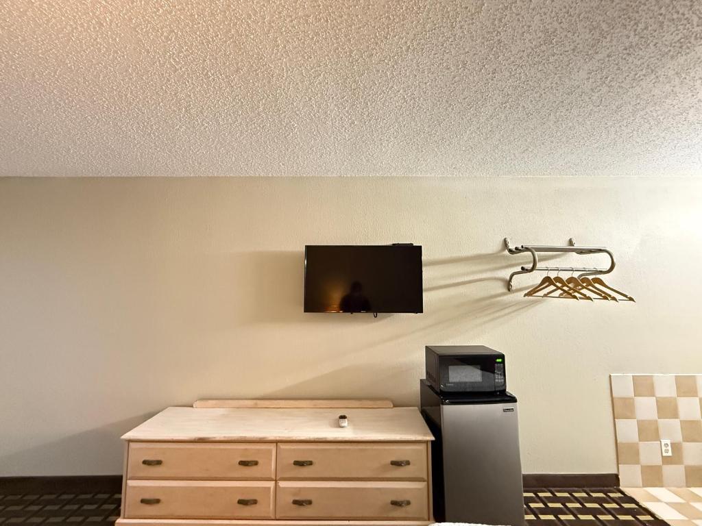 a living room with a tv on a wall at Travelodge by Wyndham-Thomasville AL in Thomasville