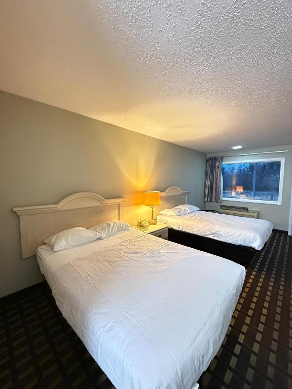 a hotel room with two beds and a window at Travelodge by Wyndham-Thomasville AL in Thomasville