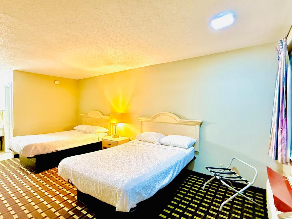 a hotel room with two beds in a room at Travelodge by Wyndham-Thomasville AL in Thomasville