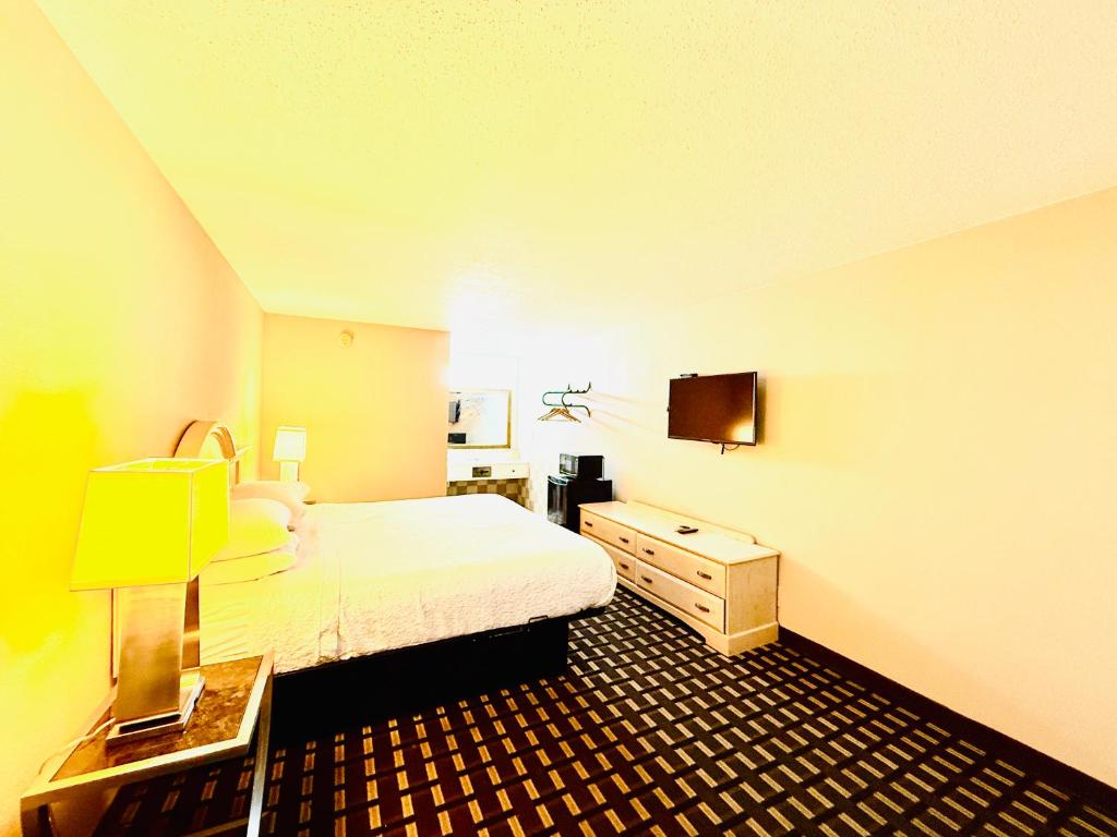 a bedroom with a bed and a desk and a tv at Travelodge by Wyndham-Thomasville AL in Thomasville
