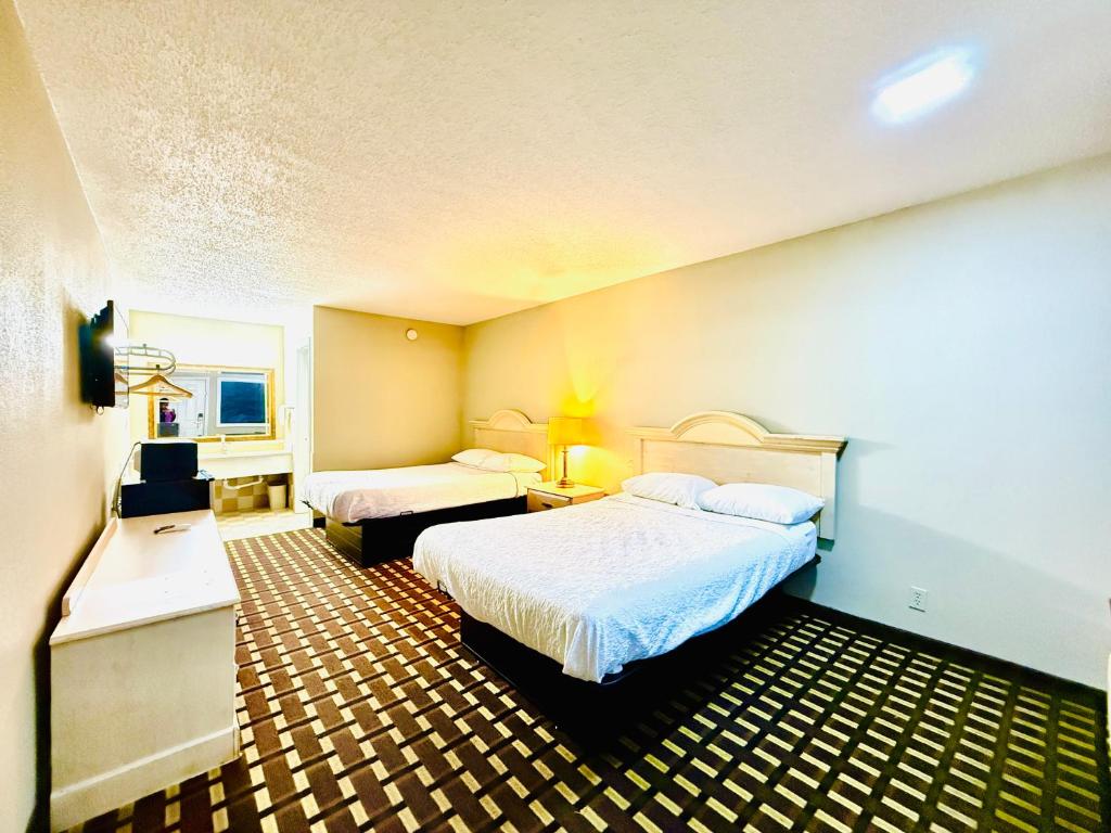 a hotel room with two beds and a desk at Travelodge by Wyndham-Thomasville AL in Thomasville