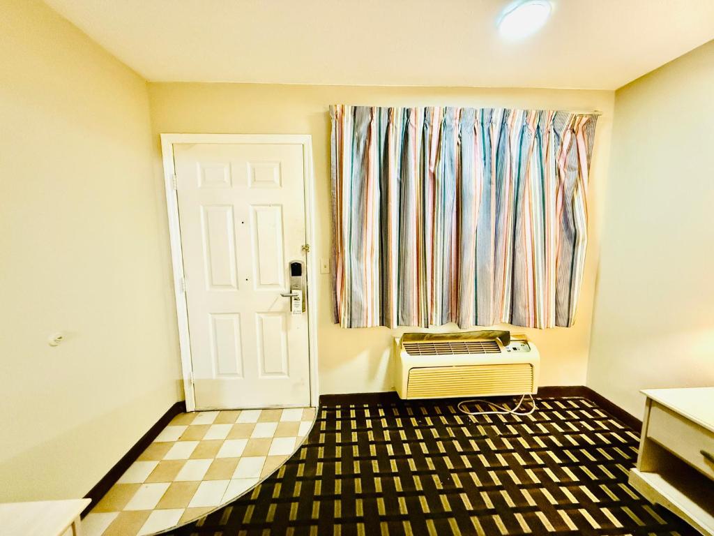 a room with a door and a radiator and a window at Travelodge by Wyndham-Thomasville AL in Thomasville