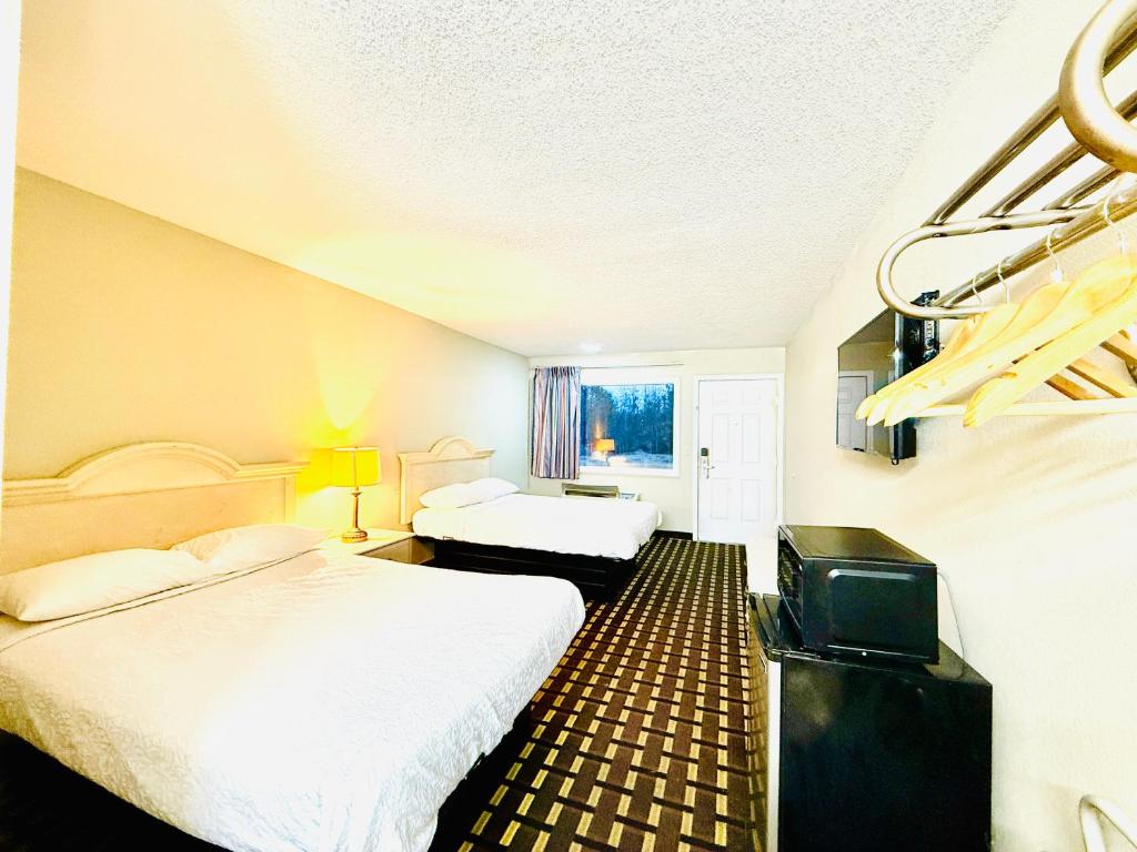 a hotel room with two beds and a tv at Travelodge by Wyndham-Thomasville AL in Thomasville
