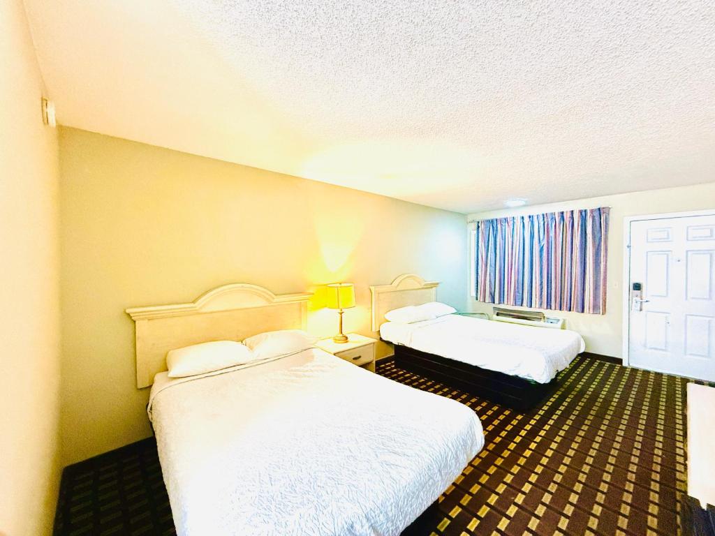 a hotel room with two beds and a window at Travelodge by Wyndham-Thomasville AL in Thomasville