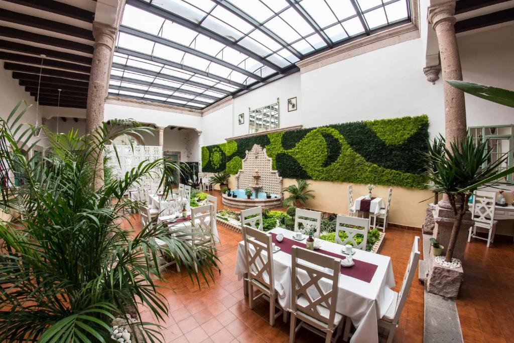 un restaurante con mesas, sillas y plantas en Casa Jose Maria, en Morelia