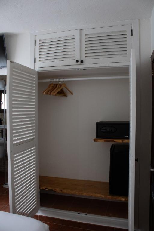 a bedroom with a closet with white cabinets at Hostal La Torre Ibiza Cap Negret in San Antonio