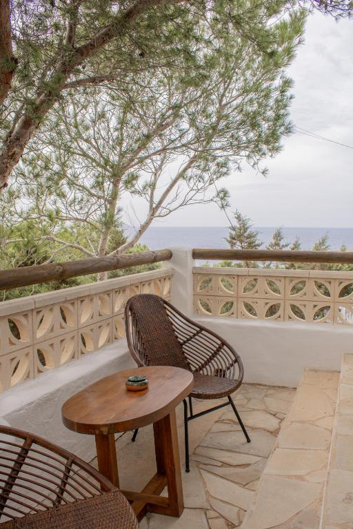 a table and chairs on a patio with a view of the ocean at Hostal La Torre Ibiza Cap Negret in San Antonio