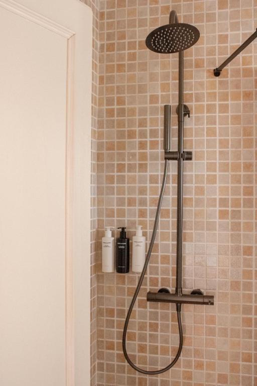 a shower with a shower head in a bathroom at Hostal La Torre Ibiza Cap Negret in San Antonio