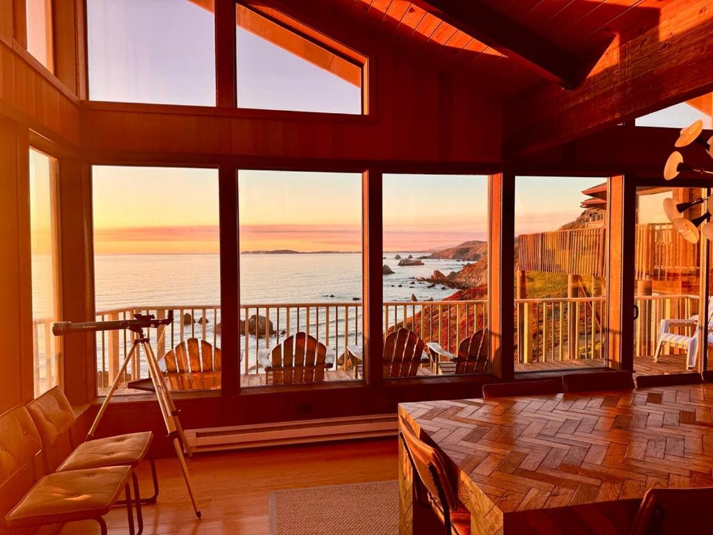 a room with large windows with a view of the ocean at Kailua Bluffs Oceanfront in Dillon Beach
