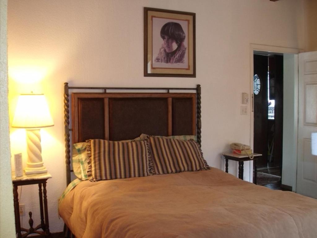 Lundeen Inn of the Arts في لاس كروسيس: غرفة نوم بسرير وصورة على الحائط