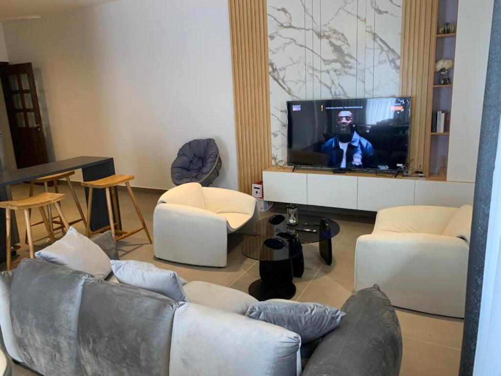 a living room with a couch and a flat screen tv at Résidences Maëlle fidjrossè Togbin in Cotonou