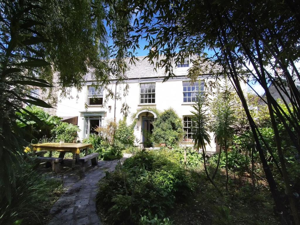 a white house with a picnic table in front of it at The Shire House in Lostwithiel