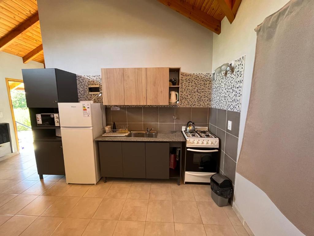 Una cocina con un refrigerador blanco y una estufa. en Blue House 6 Villa La Angostura, en Villa La Angostura