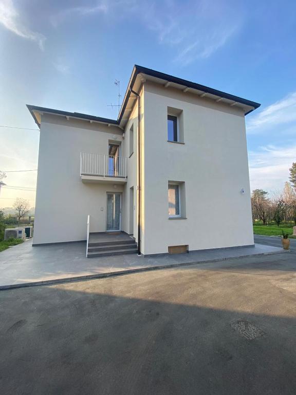 a large white house with a driveway in front of it at Tra il verde ed il Balsamico in Spilamberto