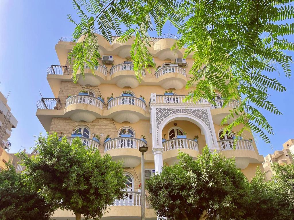 a tall yellow building with balconies on it at Xibei Lou Hotel 西北楼华人宾馆 in Cairo