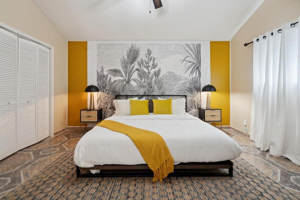 una camera da letto con un grande letto con pareti gialle di La Casita - Pool, Patio, Pacman! a Euless