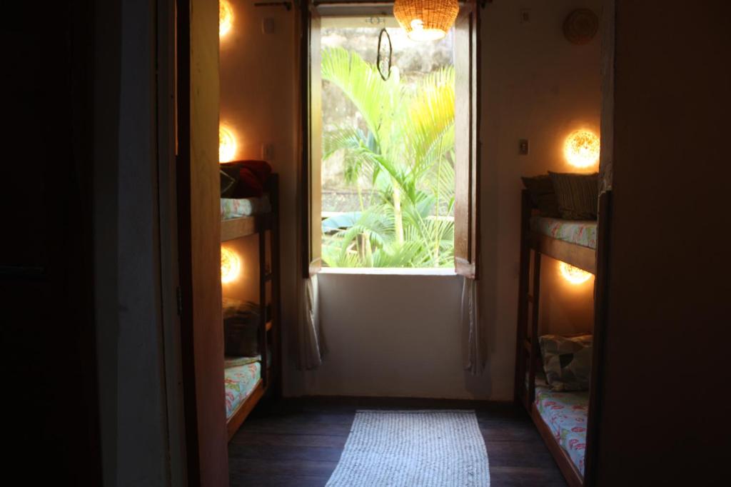 a hallway with a window with a view of a plant at Centro Cultural do Bispo Guesthouse in Salvador