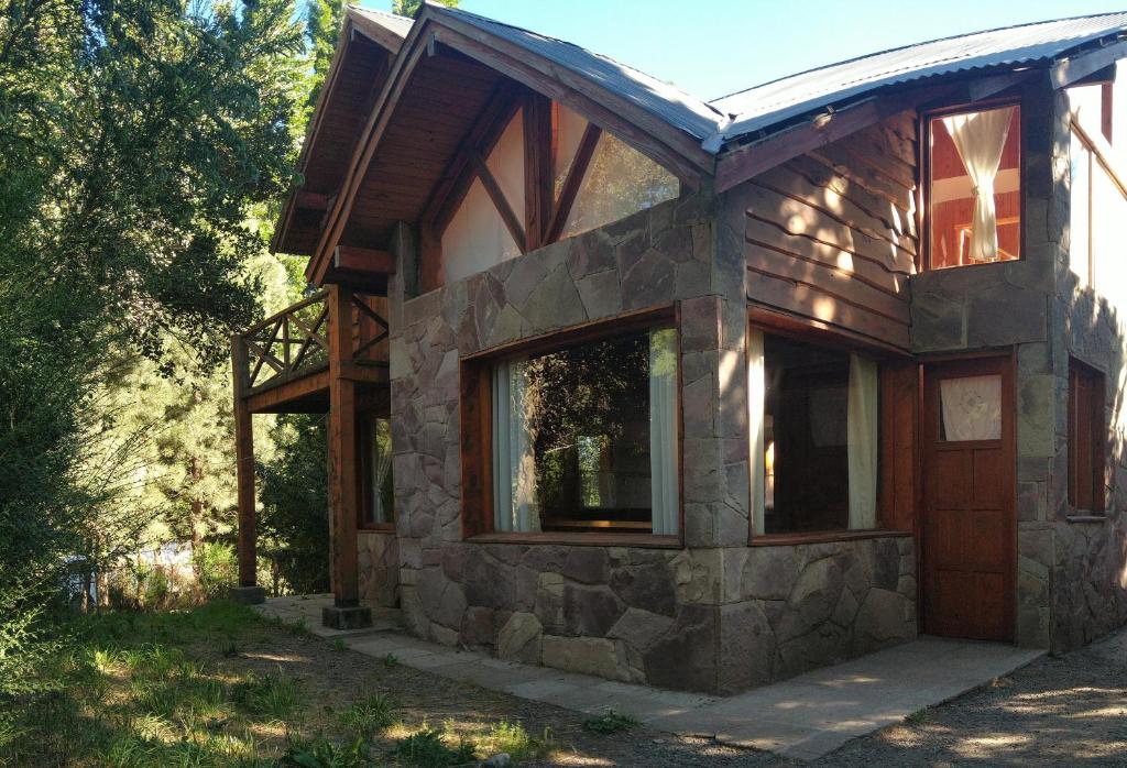 ein Steinhaus mit einem großen Fenster darauf in der Unterkunft Nuestra Ruca in San Martín de los Andes