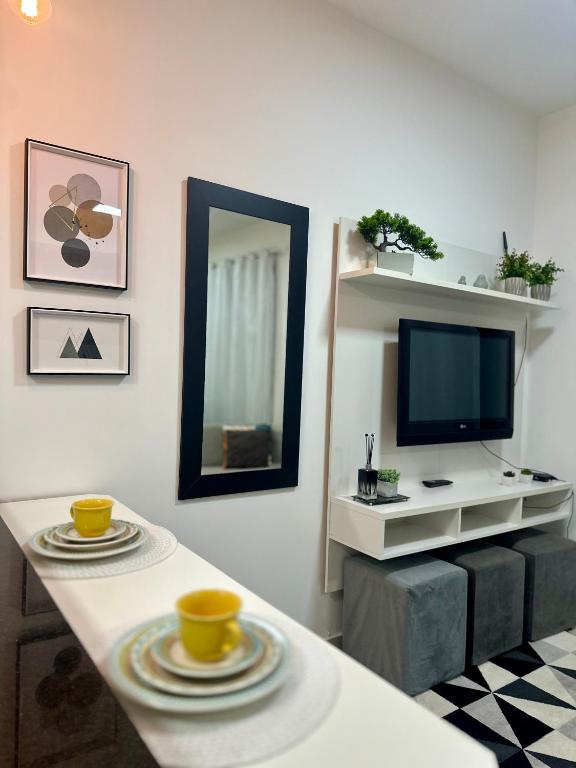 a living room with a table and a tv at Equilíbrio 1316 in Sao Jose do Rio Preto