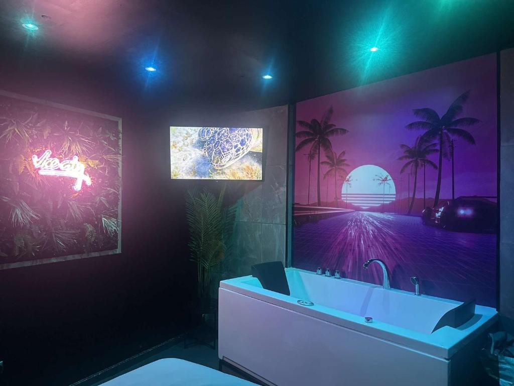 a bathroom with a sink and a painting on the wall at Vice City Expérience urbaine et romantique in Mons-en-Baroeul
