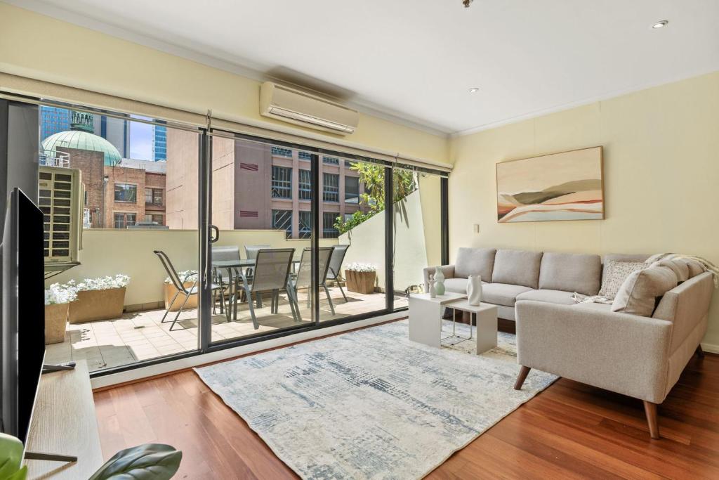 a living room with a couch and a table at Modern Comfort in the Heart of Sydney in Sydney