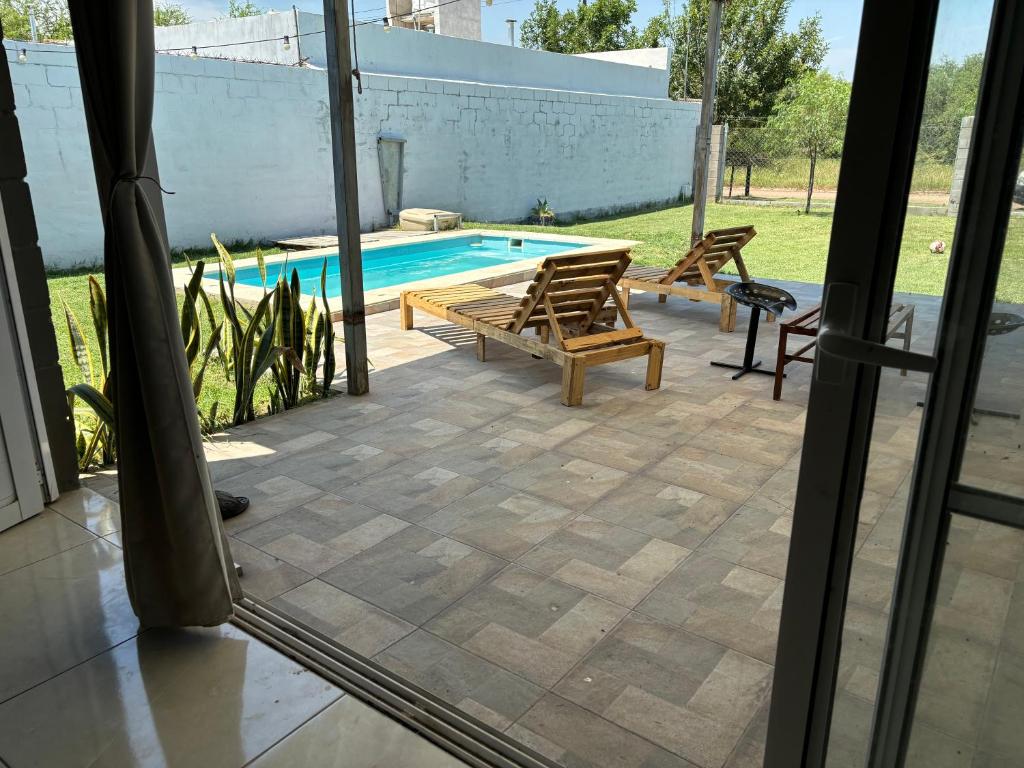 a patio with two chairs and a swimming pool at El quincho in Villa María