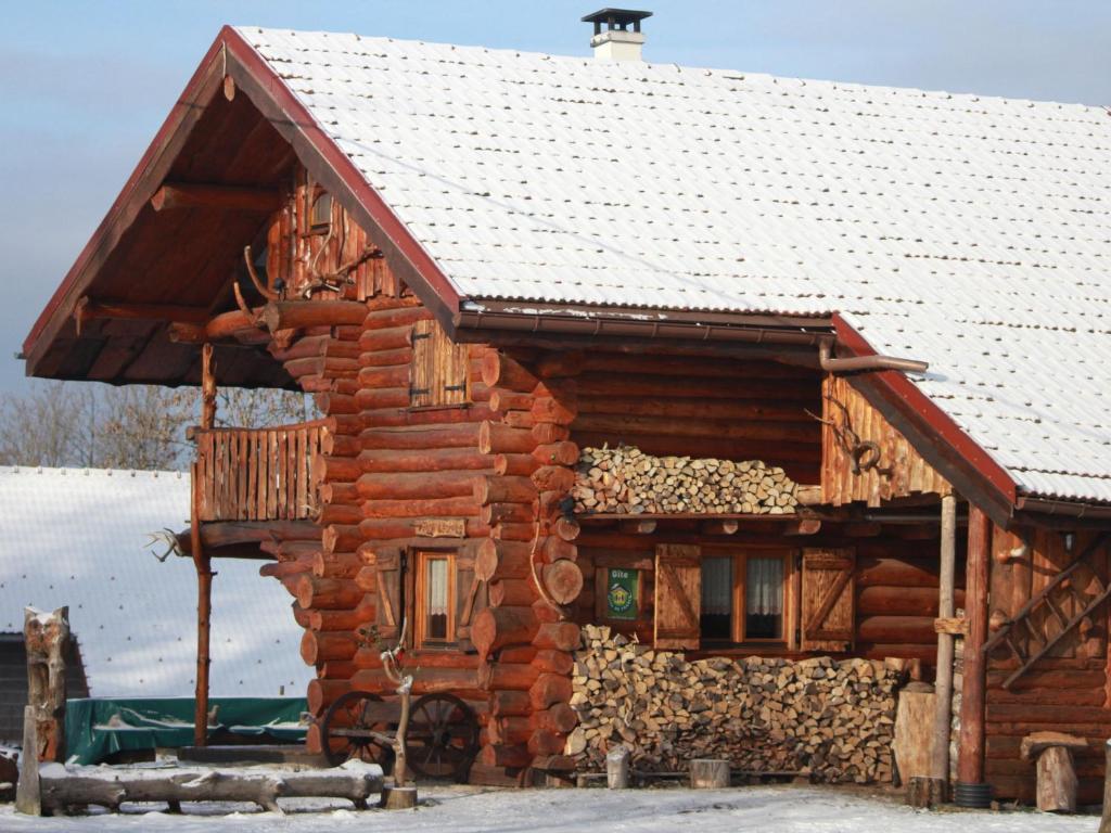 une cabane en rondins dotée d'un tas de bois de chauffage dans l'établissement Fuste insolite avec balcon et terrasse dans les Vosges - FR-1-589-241, à Le Tholy