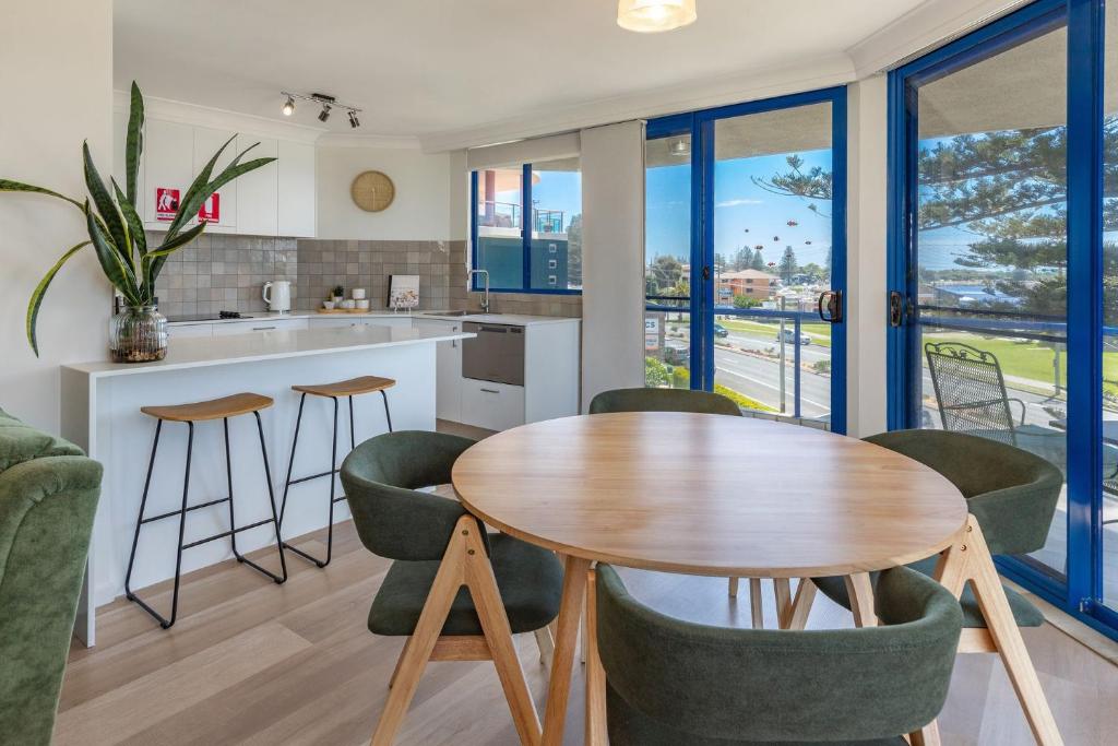 a kitchen and living room with a table and chairs at Heritage 301 in Tuncurry