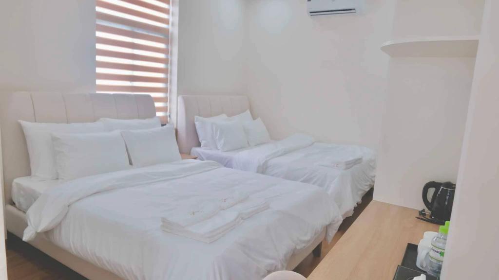 two beds in a room with white sheets and pillows at At De June Homestay 203 in Cu Lao Thu