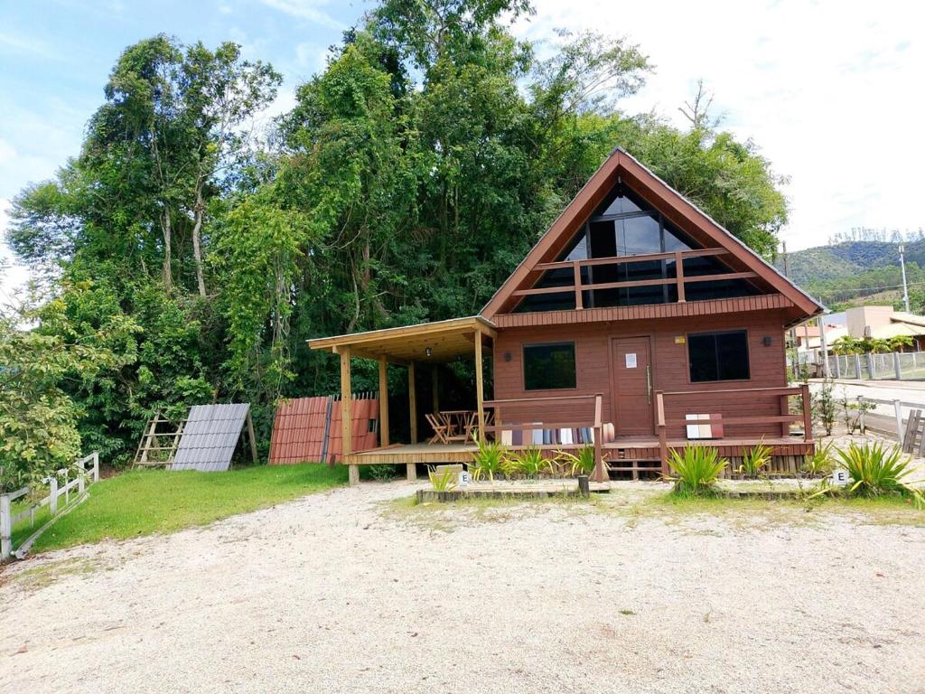 a small house on a beach with trees at Pousada Vale das Pedras in Pedras Grandes