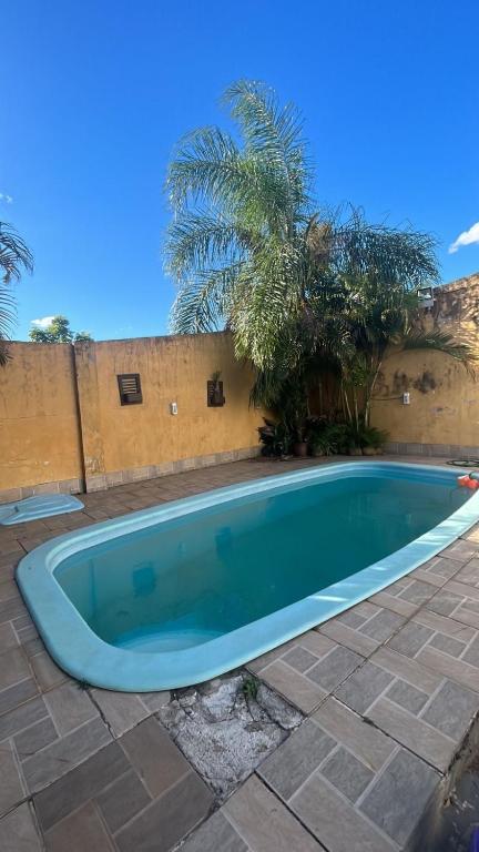 a swimming pool in a yard with a fence and trees at Acomodação no centro da cidade com piscina in São Gabriel