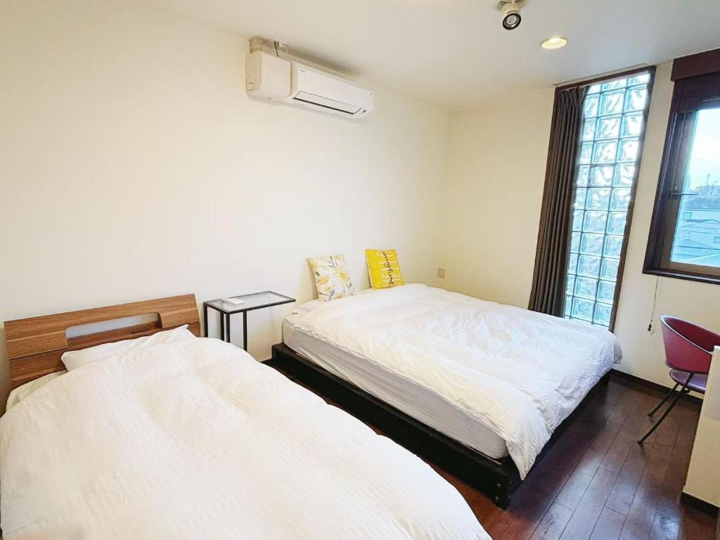 a bedroom with two beds and a window at 颯House 4 in Osaka