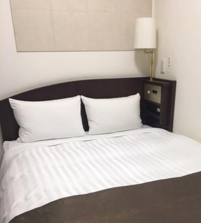Postel nebo postele na pokoji v ubytování Fuchu Urban Hotel Annex