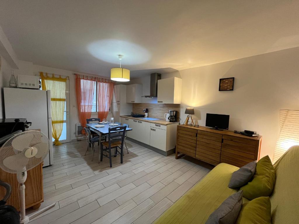 une cuisine et un salon avec un canapé et une table dans l'établissement Appartement cosy Sète, 2 pièces, 4 pers, rez-de-chaussée, WIFI, animaux admis - FR-1-338-599, à Sète