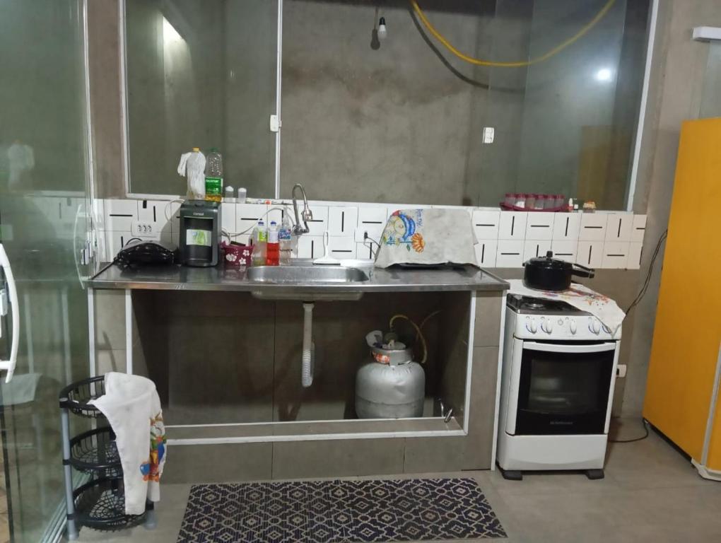 una piccola cucina con lavello e fornello di família Dias a Peruíbe