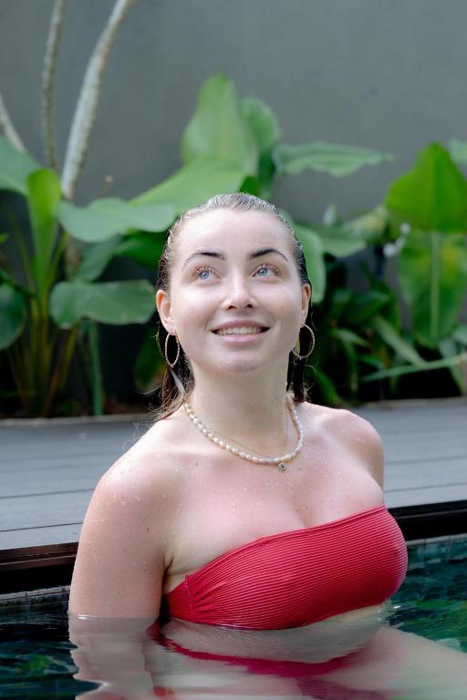 a woman in a red dress in a swimming pool at Bohemian Nest in Negombo