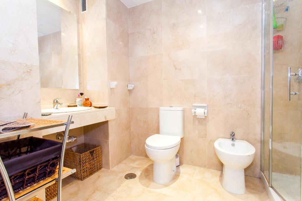 a bathroom with a toilet and a sink and a shower at Casa Singular , parking gratis in Jerez de la Frontera