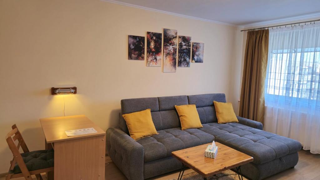 ein Wohnzimmer mit einem blauen Sofa und gelben Kissen in der Unterkunft Tineretului in Bukarest