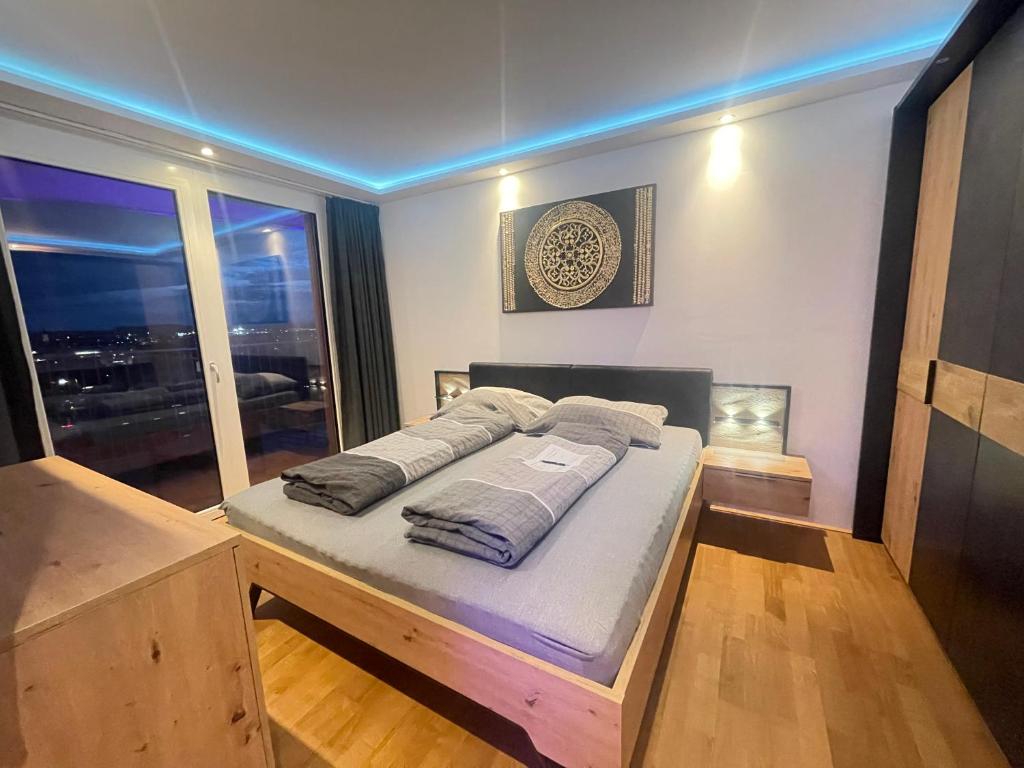 Un dormitorio con una cama en una habitación con ventana. en 100 qm Penthouse, Self-Check-In, 2 Parkplätze, en Graz