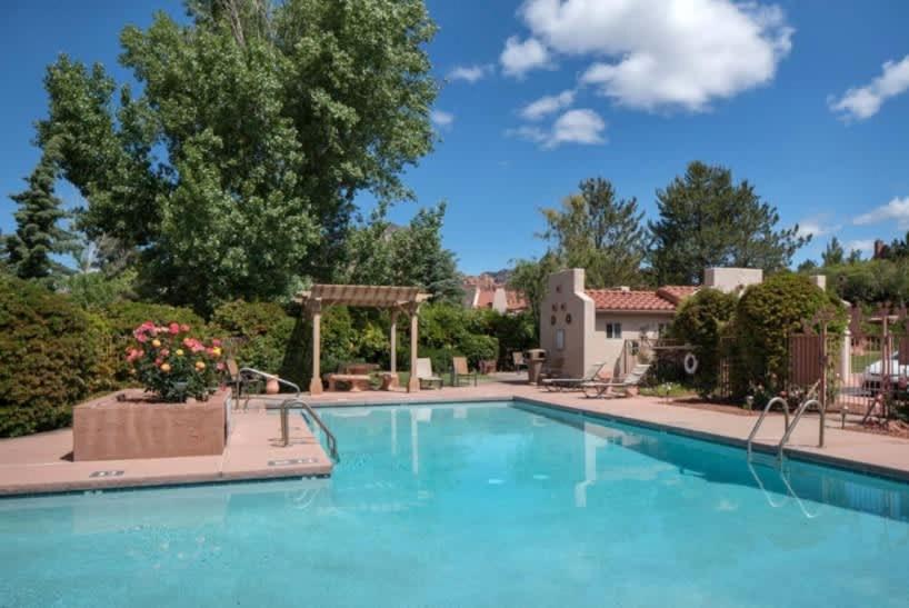 a swimming pool in a resort with blue water at Refreshing Sedona Sanctuary with Pool and Hot Tub for Family in Sedona