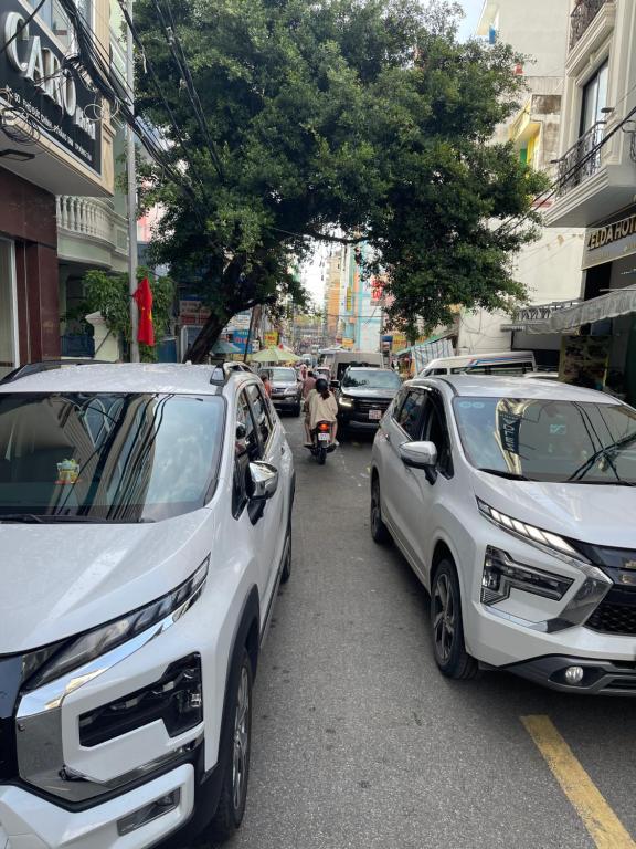 two white cars parked on the side of a street at Hằng nga luxury hotel in Vung Tau