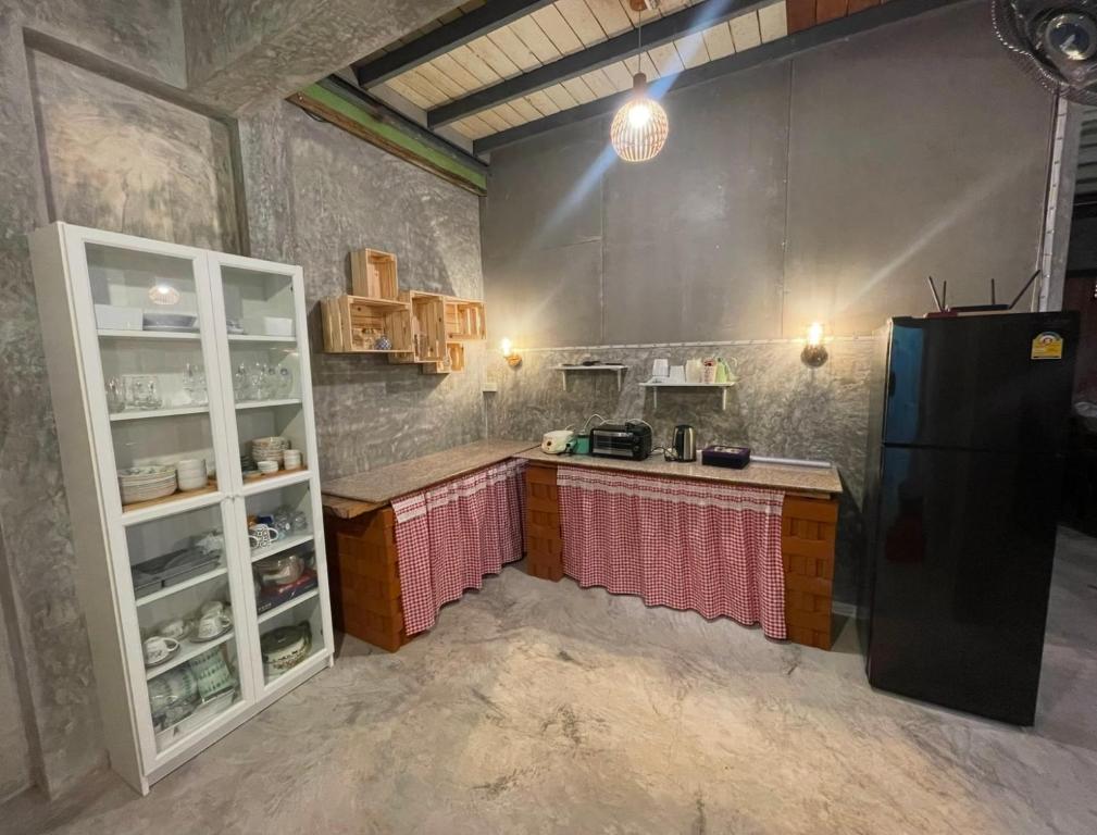 a kitchen with a black refrigerator and a counter at บ้านแสนรัก Casa Dolce Casa, Prakhon Chai in Prakhon Chai